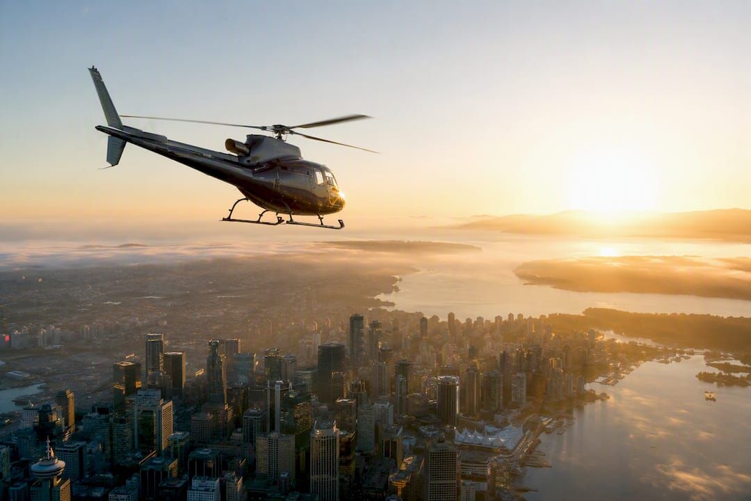 Helicopter flying over city at sunrise