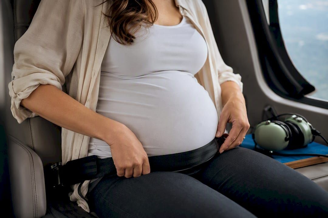 Pregnant passenger positioning helicopter seatbelt