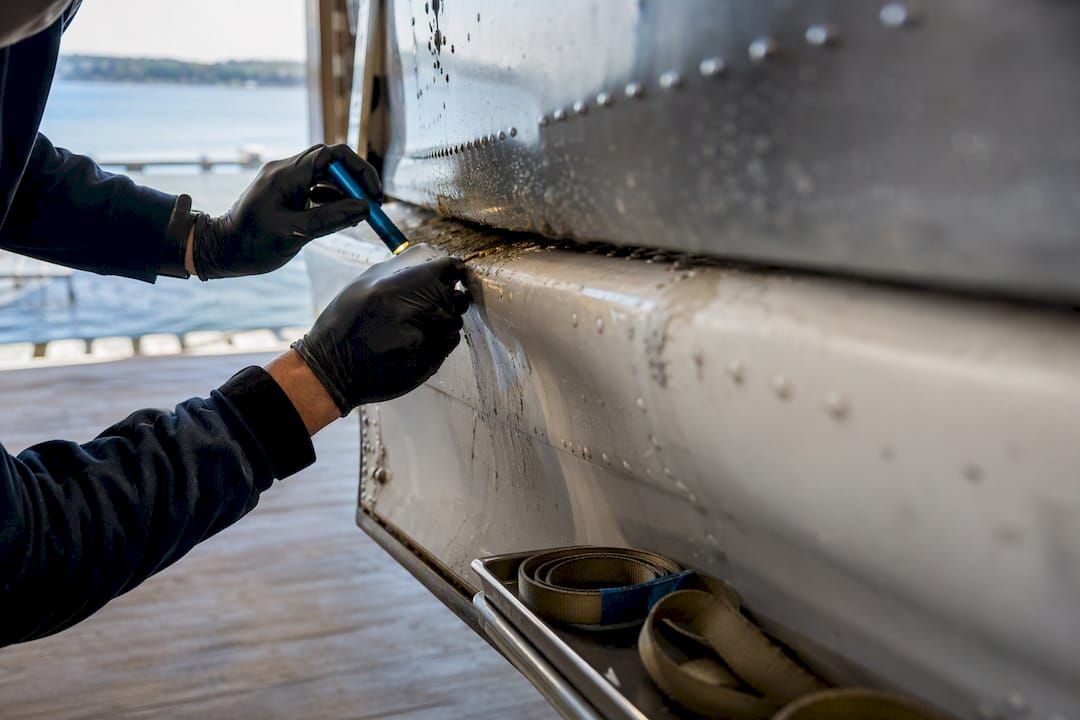 Technician inspecting seaplane float corrosion
