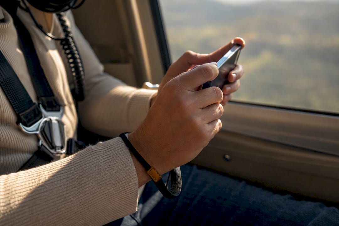 Passenger securing phone during helicopter flight